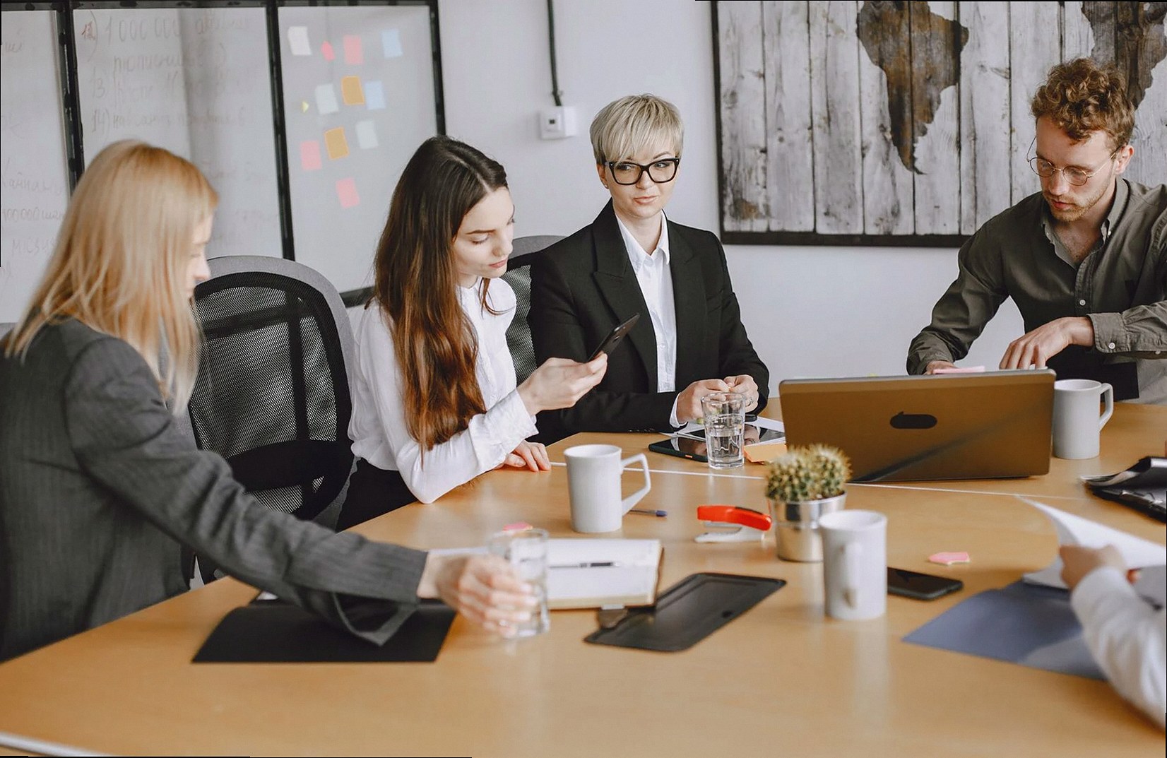 A group of business professionals working together at an office meeting table.